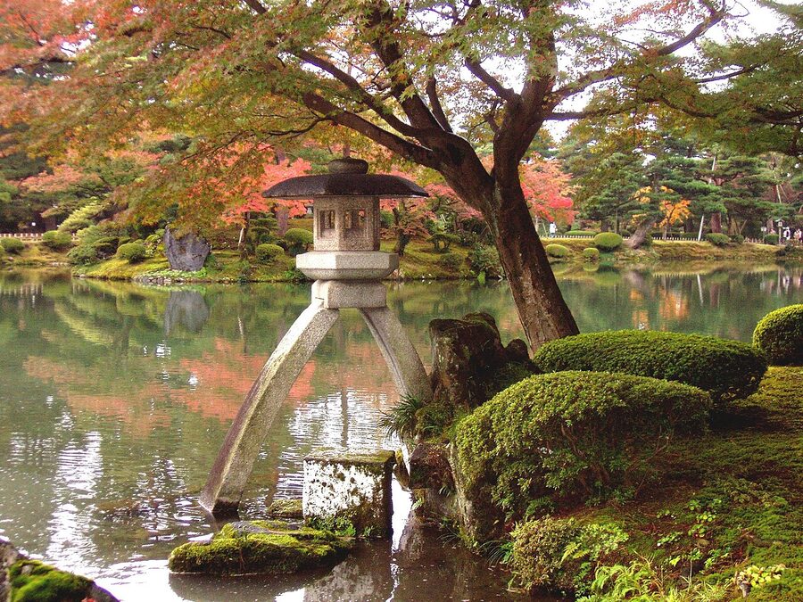 Kenrokuen Garden with two-legged Kotoji stone lantern beside Kasumiga-ike pond in autumn
