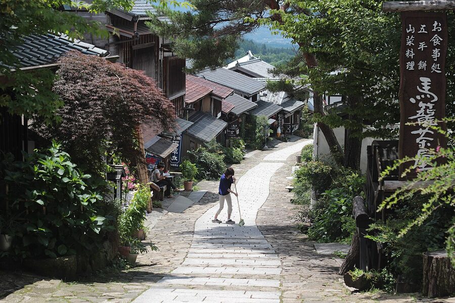 Hand-tied straw brooms hanging outside a Magome shop