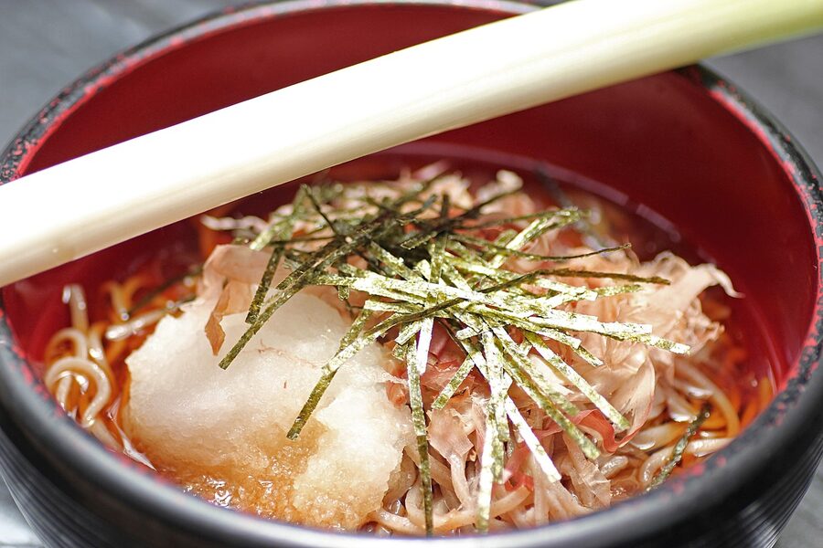 A bowl of mountain-vegetable soba on a wooden table