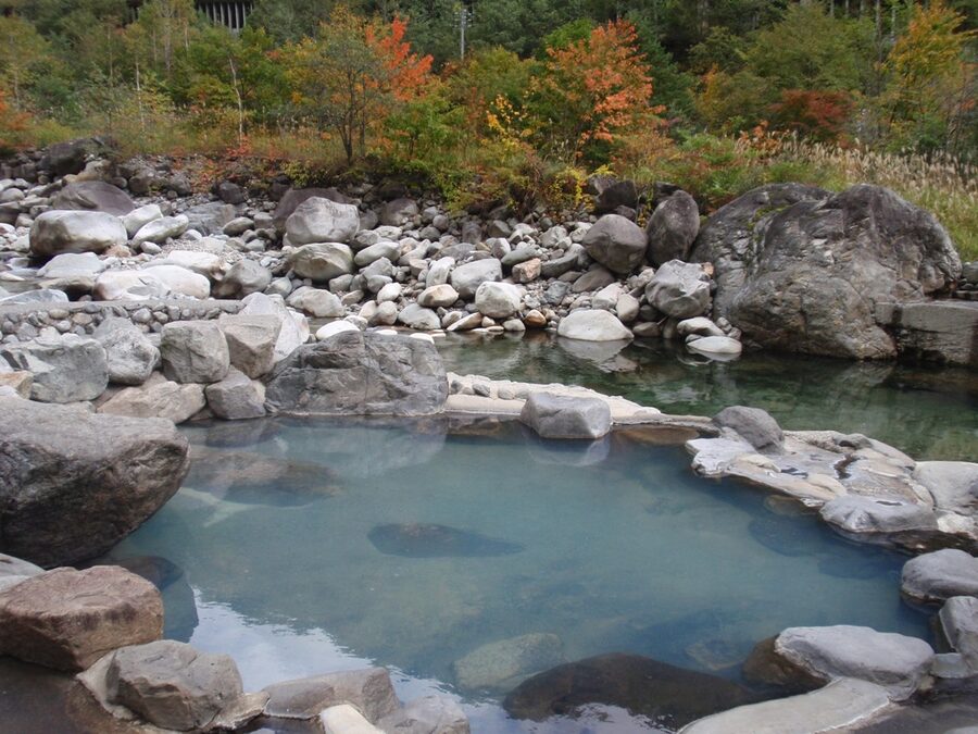 An open-air bath at a Shin-Hotaka ryokan with mountain views