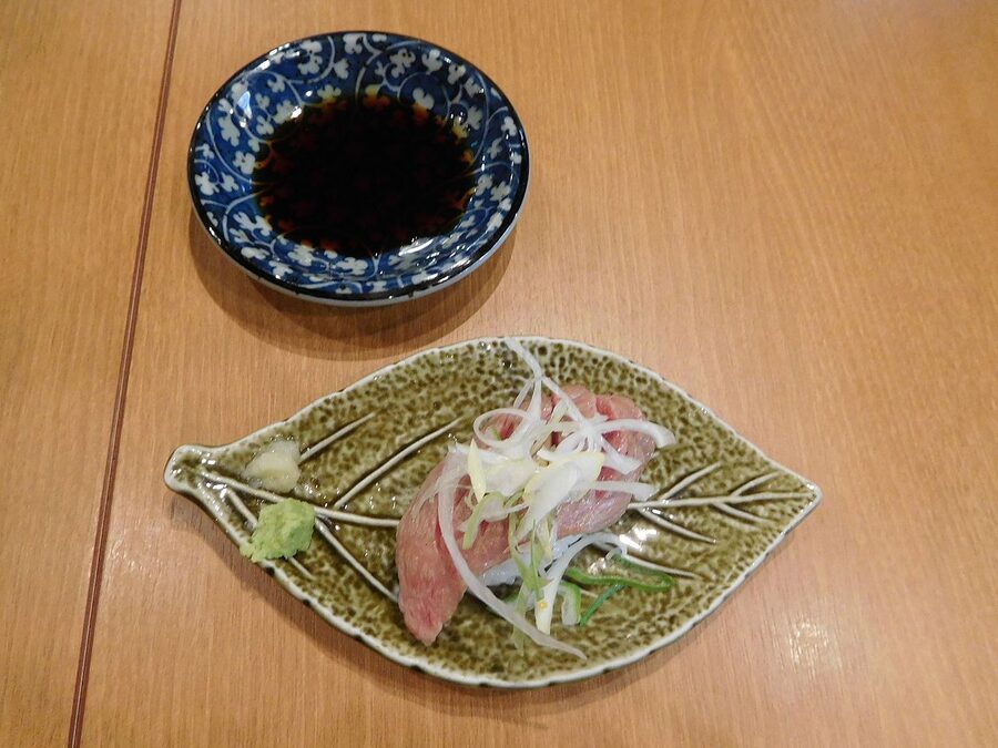 Hida beef sushi served on a rice cracker plate