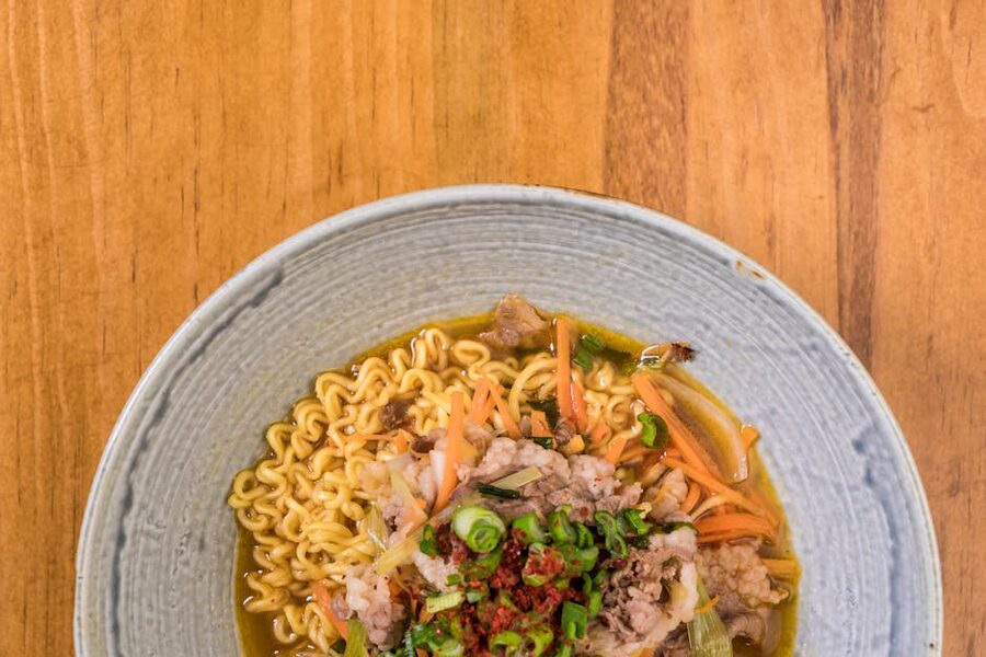 Ramen bowl with toppings on wooden surface