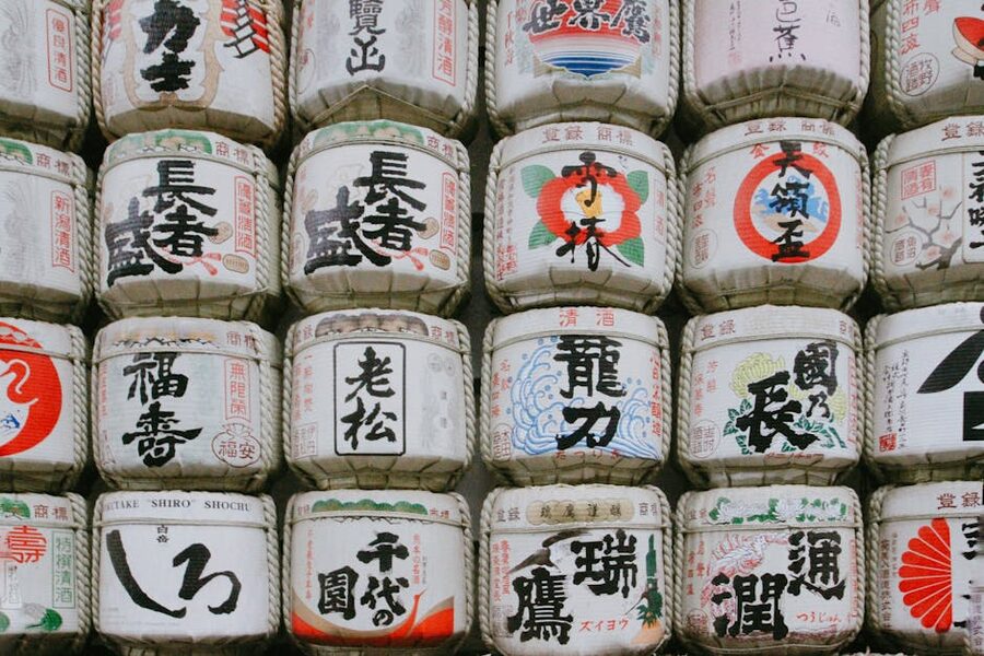 Stacked traditional Japanese sake barrels with calligraphy
