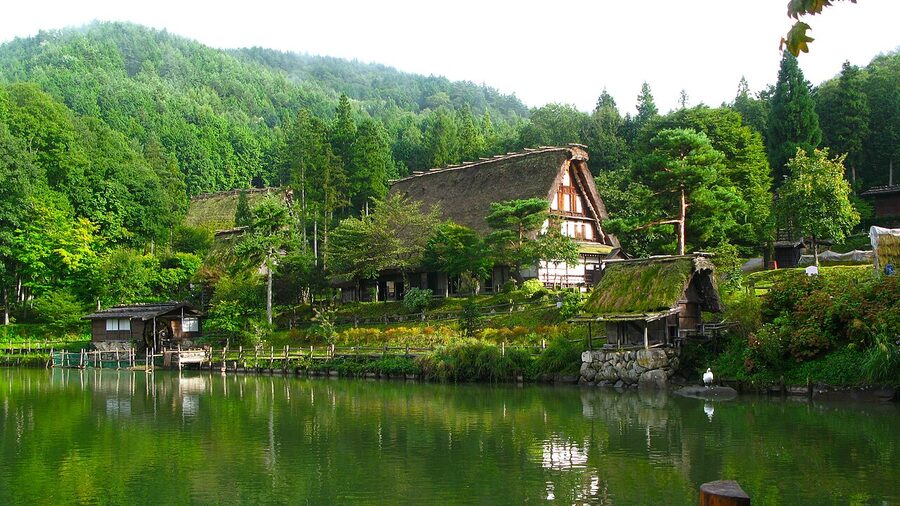 Lush green foliage and thatched roofs in summer at Hida Folk Village